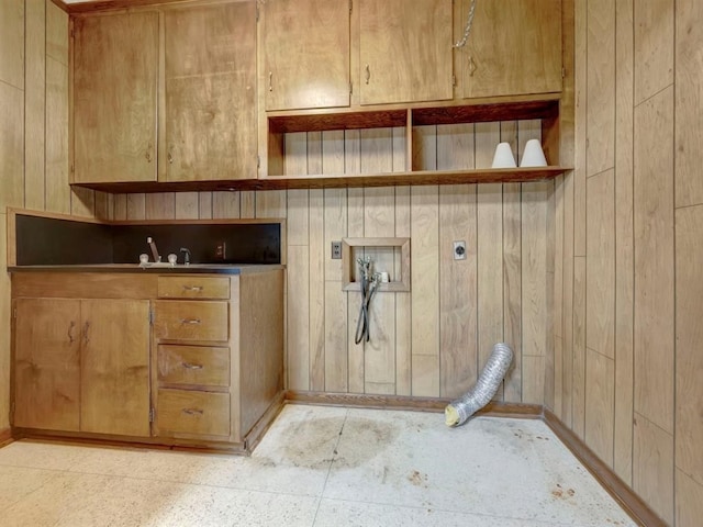 laundry area featuring wood walls, cabinets, and hookup for an electric dryer