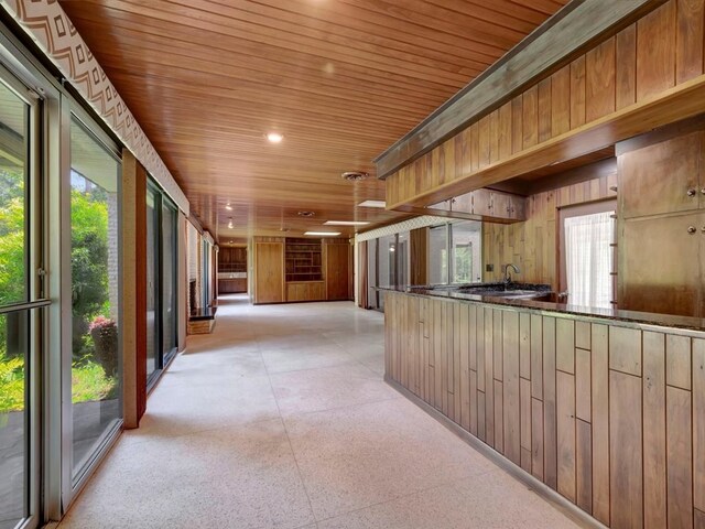 kitchen featuring wooden walls and appliances with stainless steel finishes