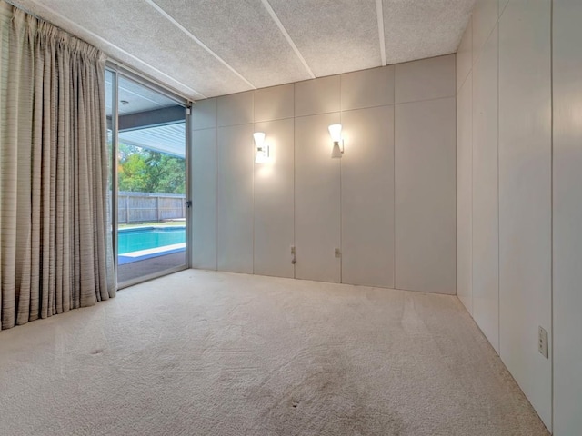 carpeted empty room with a textured ceiling