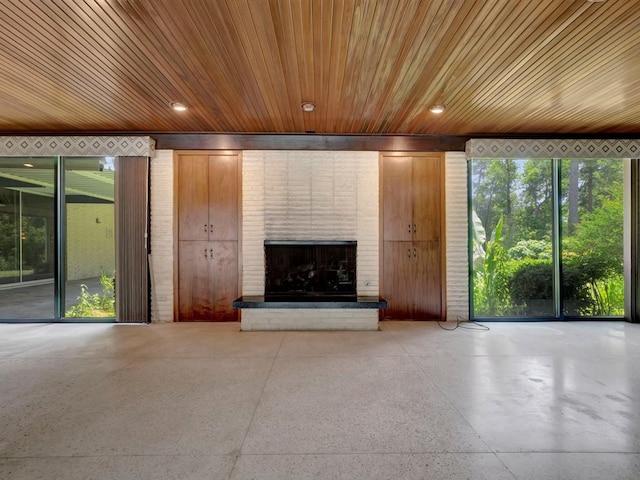 unfurnished living room featuring a fireplace and wooden ceiling