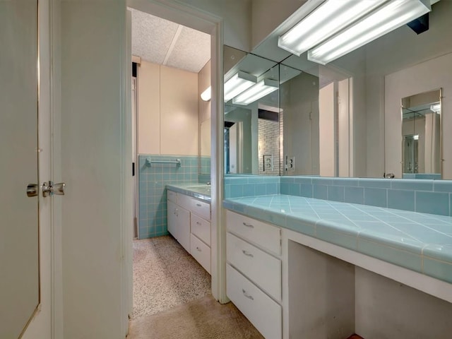 bathroom with vanity and tile walls