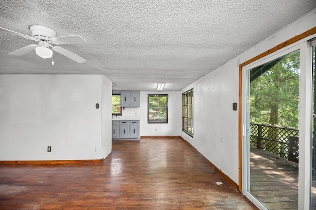 390 County Road 076, Jasper, TX 75951 - unfurnished living room featuring dark wood-style flooring, a textured ceiling, baseboards, and ceiling fan