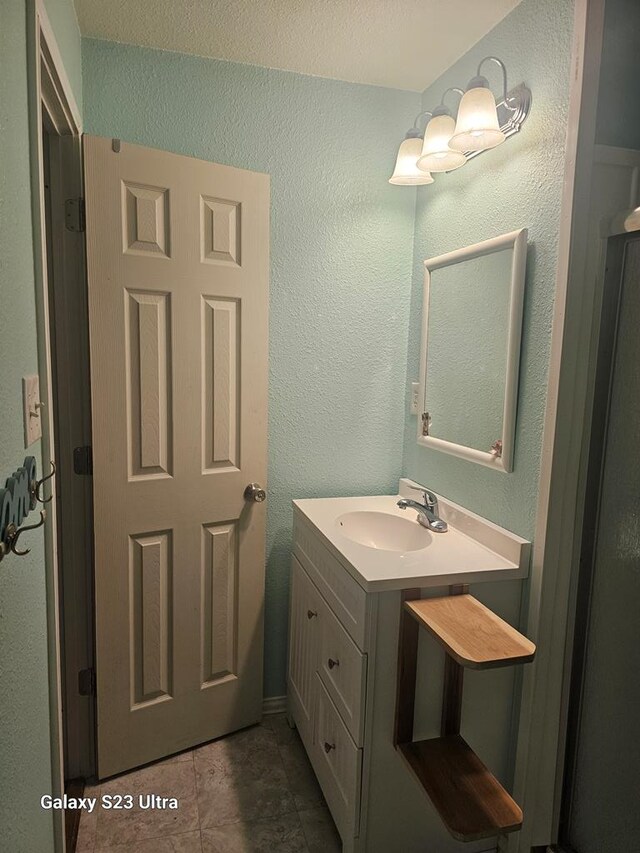 bathroom featuring vanity and a textured wall