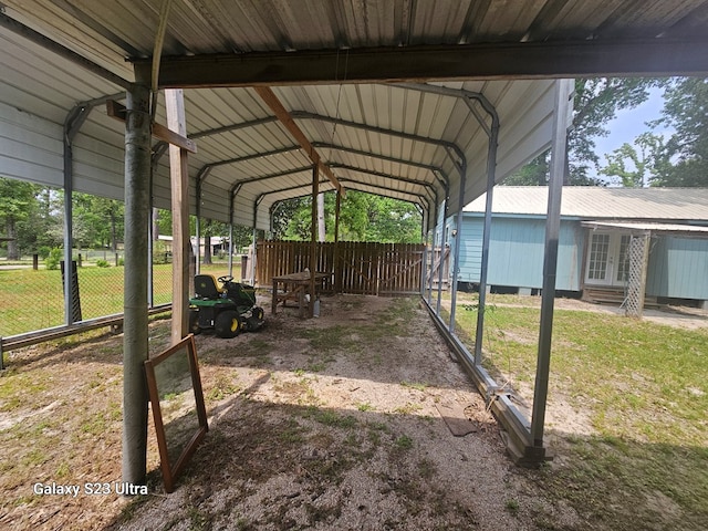 view of car parking with fence, a detached carport, entry steps, and french doors