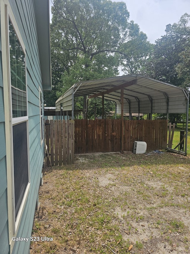 view of yard with fence and a carport