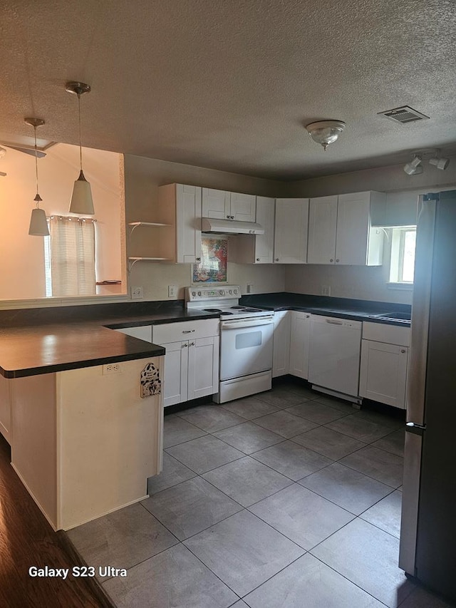 kitchen featuring a textured ceiling, dark countertops, under cabinet range hood, white appliances, and white cabinetry