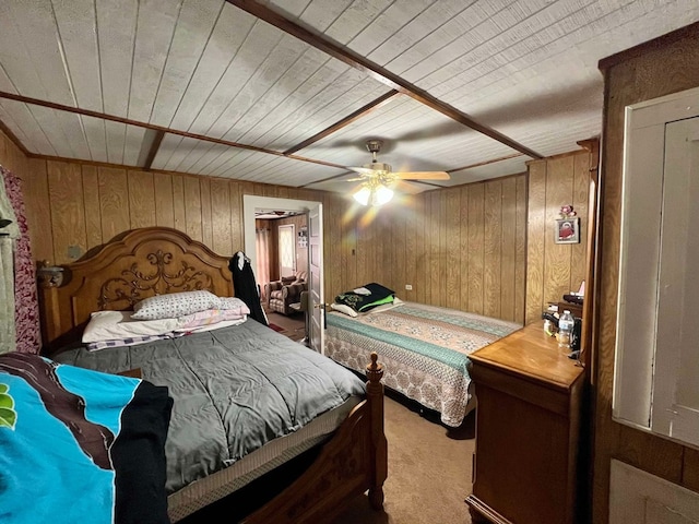 bedroom with light colored carpet, ceiling fan, and wooden walls