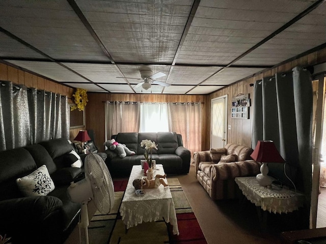 living room featuring ceiling fan and wood walls