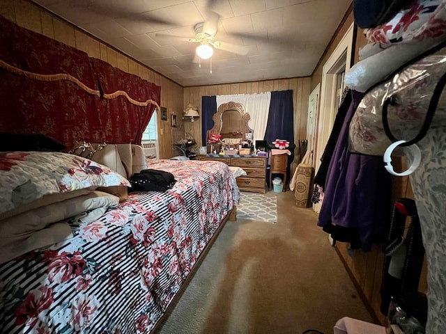 bedroom featuring light carpet, ceiling fan, and wooden walls