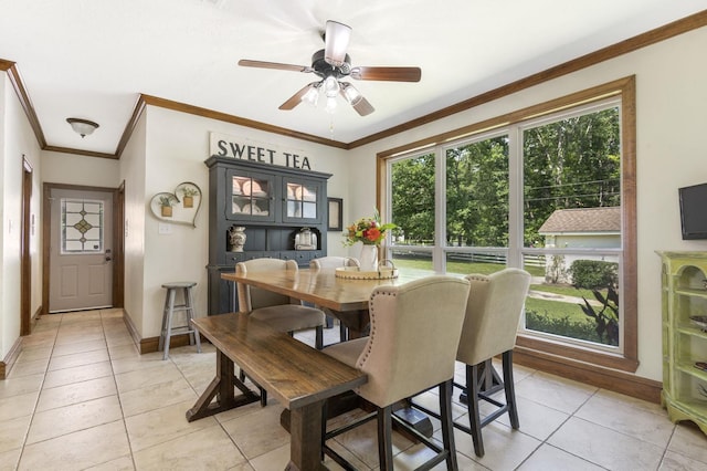 dining space with crown molding, ceiling fan, and light tile patterned floors