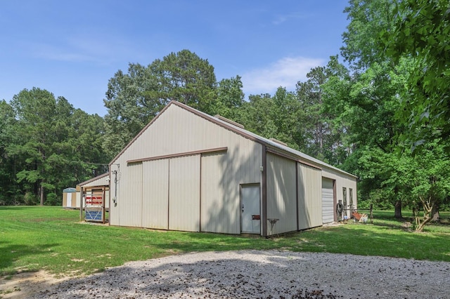 view of outdoor structure featuring a garage and a lawn