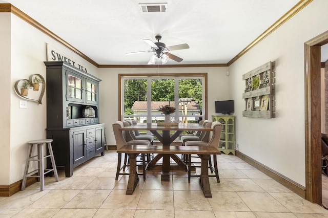 dining space with crown molding, ceiling fan, and light tile patterned floors