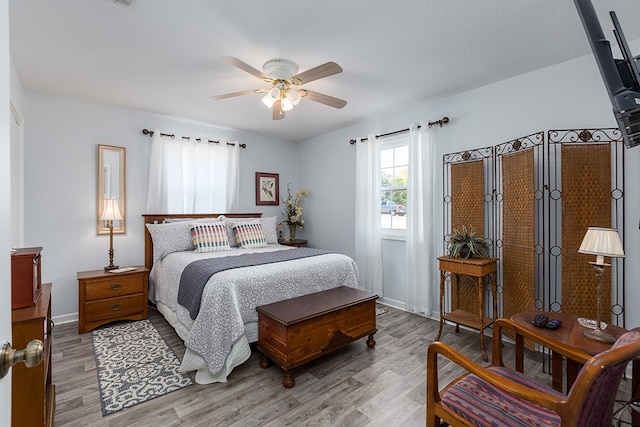 bedroom with light hardwood / wood-style flooring and ceiling fan