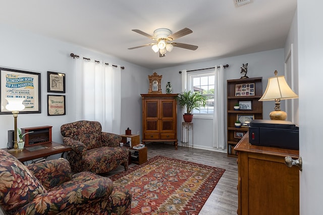 sitting room featuring dark hardwood / wood-style flooring and ceiling fan