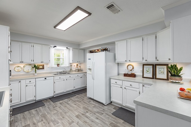 kitchen with white cabinetry, sink, and white appliances