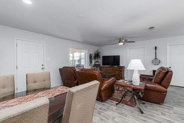 living room with crown molding, ceiling fan, light hardwood / wood-style floors, and a textured ceiling