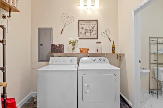 washroom with tile patterned flooring, laundry area, baseboards, washer and dryer, and electric panel