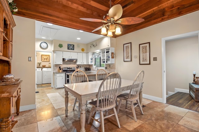 dining space featuring attic access, a ceiling fan, washer and dryer, wooden ceiling, and baseboards