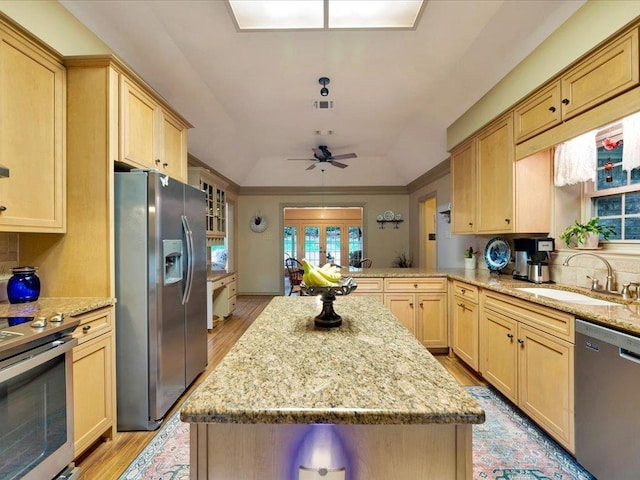 kitchen featuring kitchen peninsula, light wood-type flooring, stainless steel appliances, and ceiling fan