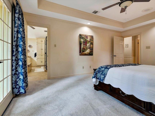 bedroom with a tray ceiling, multiple windows, ceiling fan, and light carpet