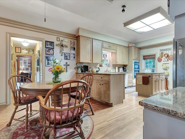 kitchen featuring backsplash, light stone counters, a center island, and light wood-type flooring