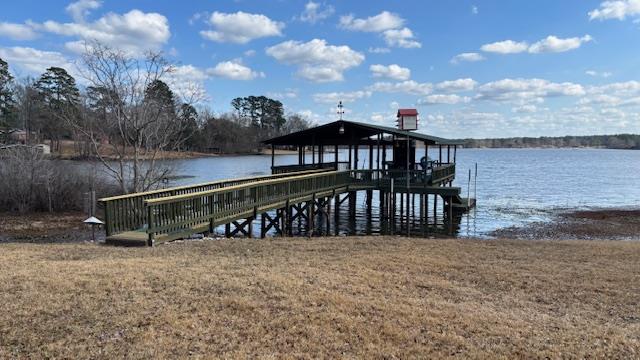 dock area with a lawn and a water view