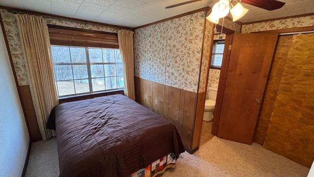 carpeted bedroom with ornamental molding and ceiling fan