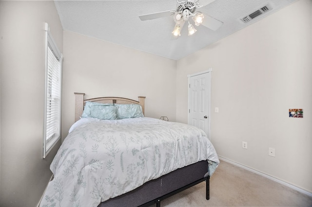 bedroom with visible vents, baseboards, light carpet, and multiple windows