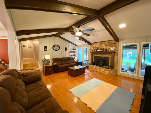 living room with vaulted ceiling with beams, ceiling fan, and light wood-type flooring