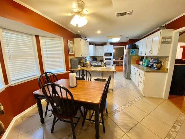 dining area with light tile patterned floors, ceiling fan, and crown molding