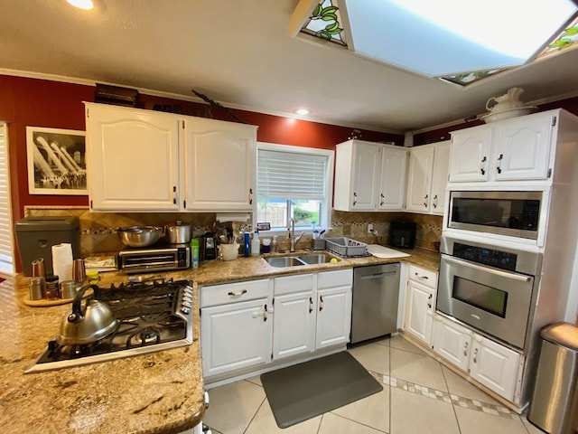 kitchen featuring crown molding, white cabinetry, sink, and stainless steel appliances