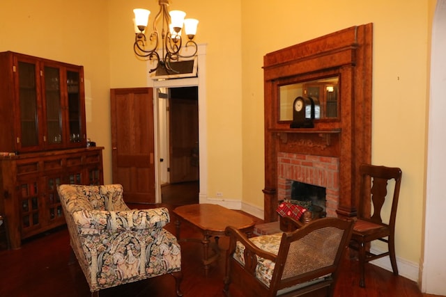 living area with a fireplace, dark hardwood / wood-style flooring, and an inviting chandelier