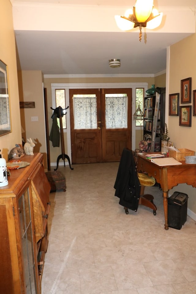 entrance foyer with crown molding and french doors