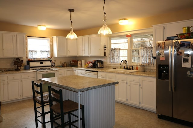 kitchen with white cabinetry, white appliances, a center island, and a kitchen bar