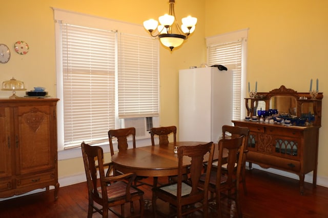 dining space with dark hardwood / wood-style floors and a notable chandelier