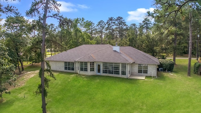 627 Shoreline Dr, Brookeland, TX 75931 - rear view of property featuring a yard, a patio area, a chimney, and view of scattered trees