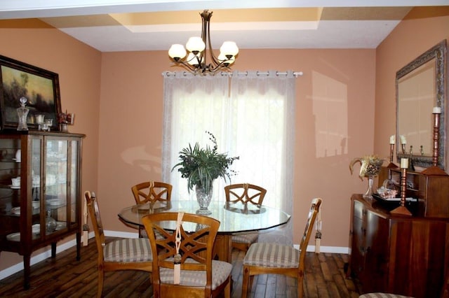 dining space featuring dark hardwood / wood-style floors and an inviting chandelier