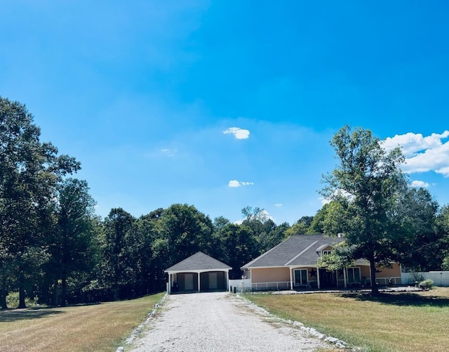 single story home with a front yard, an outbuilding, and a garage