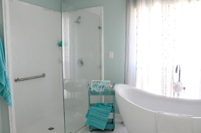 bathroom with shower with separate bathtub and a wealth of natural light