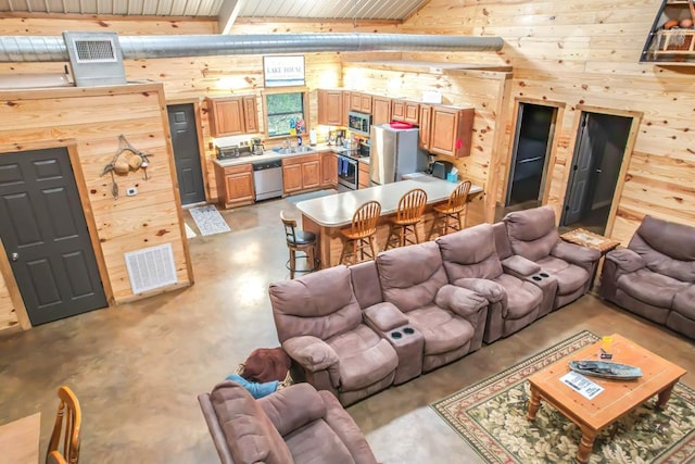 living room featuring wood walls, sink, wood ceiling, and beam ceiling