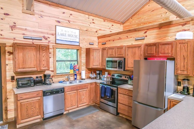 kitchen with wooden walls, sink, stainless steel appliances, and vaulted ceiling