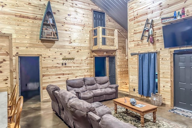 living room with concrete flooring, wooden walls, and vaulted ceiling