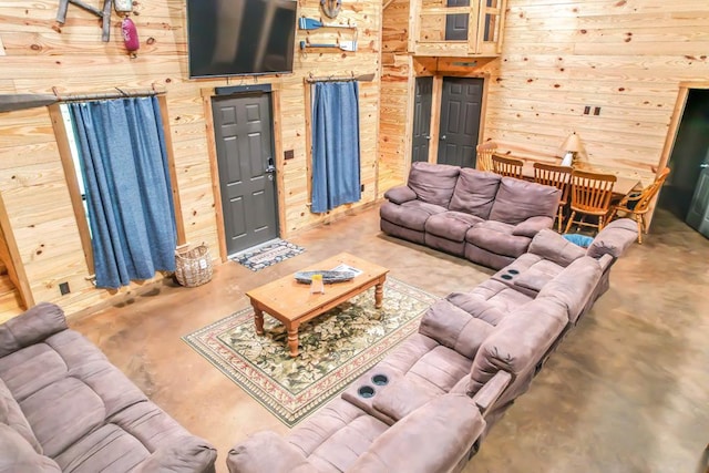 living room featuring concrete flooring and wood walls