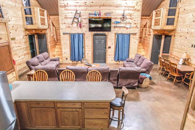 living room with high vaulted ceiling, wooden walls, and wood ceiling