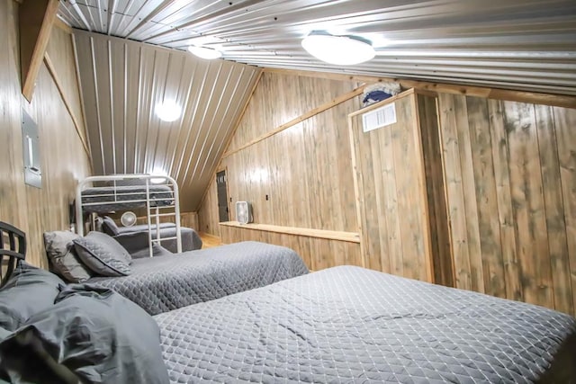 bedroom featuring wood walls and vaulted ceiling