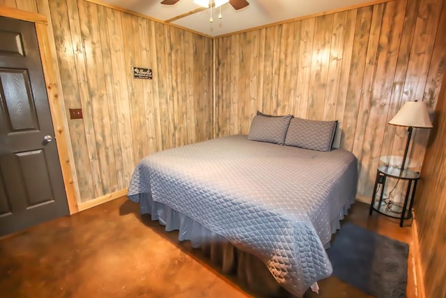 bedroom with ceiling fan and wood walls