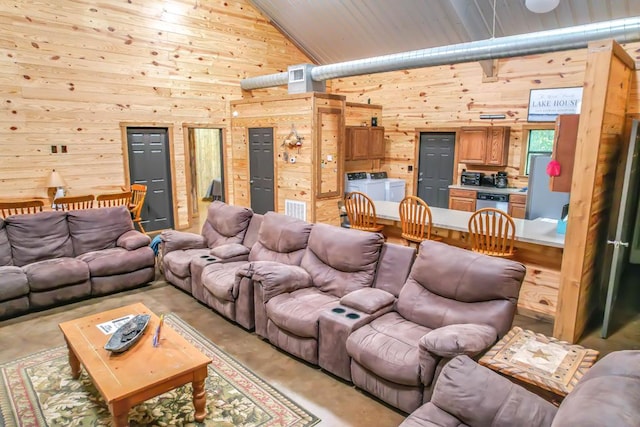 cinema room featuring wooden walls, high vaulted ceiling, and independent washer and dryer