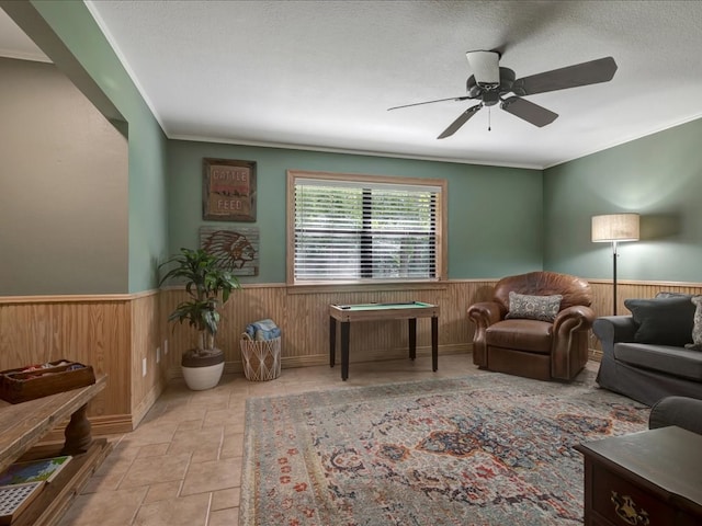 3274 Cc Rd, Diboll, TX 75941 - sitting room with wainscoting, wood walls, a ceiling fan, stone finish flooring, and ornamental molding