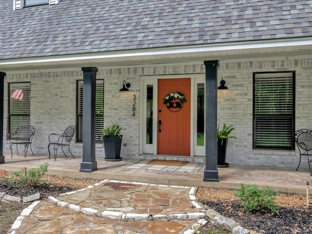 3274 Cc Rd, Diboll, TX 75941 - doorway to property with a porch, brick siding, and a shingled roof