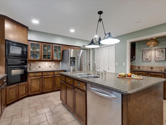3274 Cc Rd, Diboll, TX 75941 - kitchen featuring black appliances, a sink, decorative backsplash, an island with sink, and light stone finish flooring